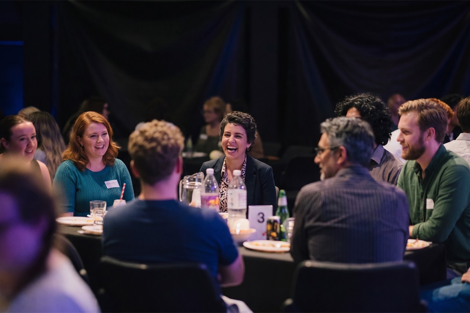 Guests laughing around the table at a recent night